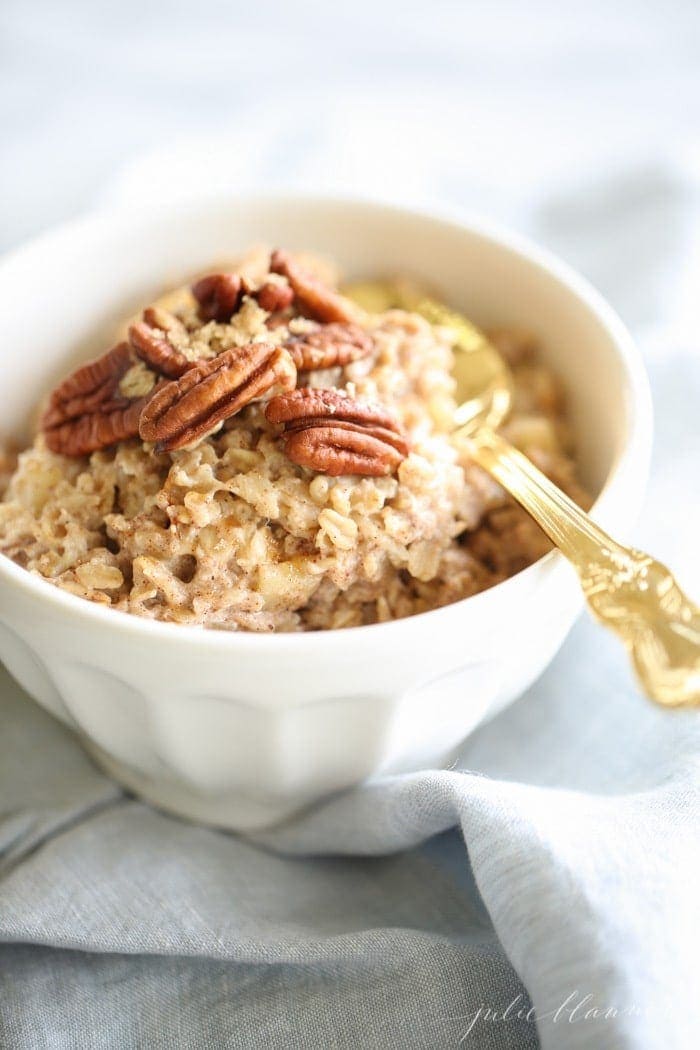 Apple Pie Oatmeal in a white bowl topped with pecans