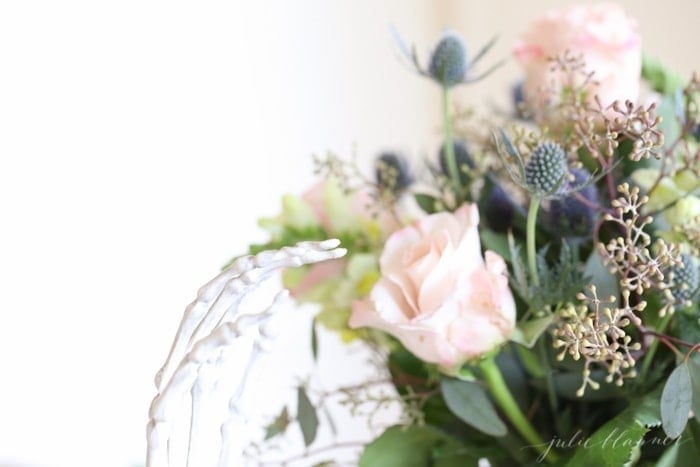 pink and blue Halloween flowers with a skeleton hand reaching up