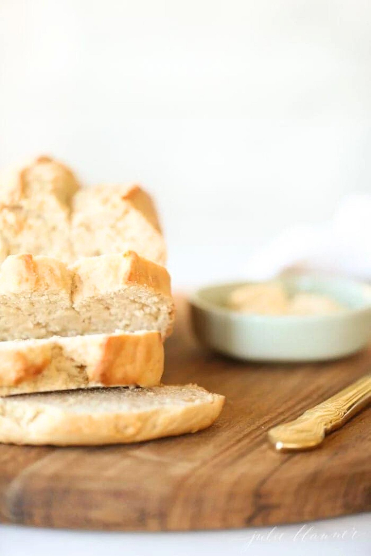 A slice of honey beer bread on a wooden cutting board.