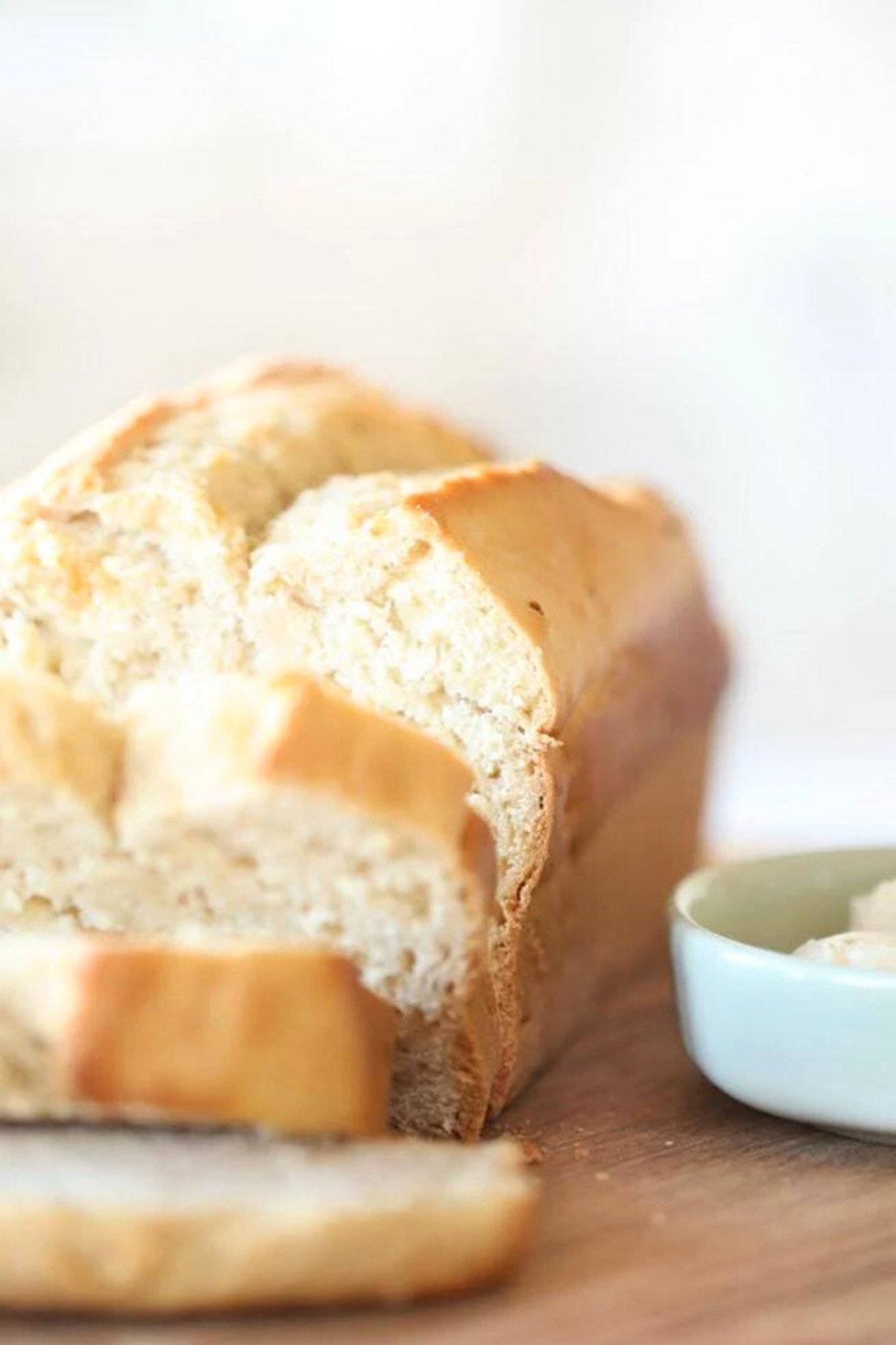 A loaf of honey beer bread is sitting on a cutting board.