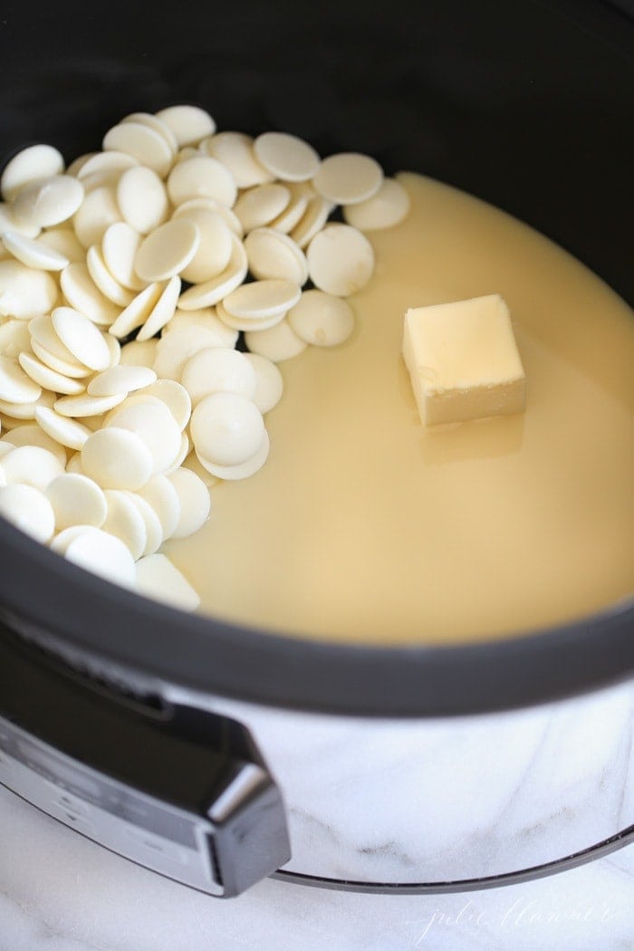 White chocolate wafers and butter melting into white chocolate crockpot fudge.