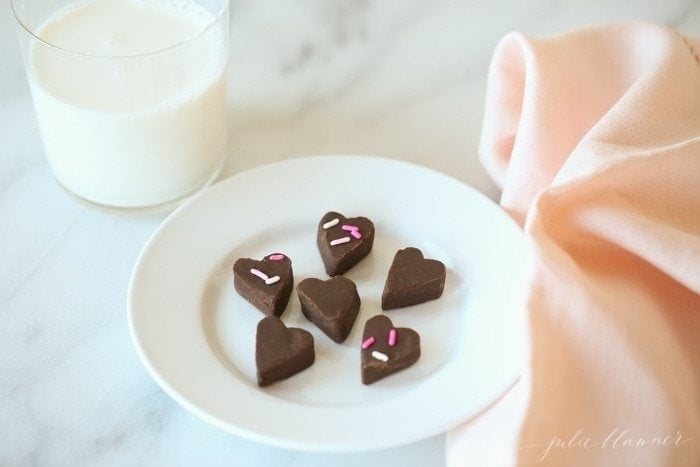 Traditional chocolate fudge cut into pieces and served on a white plate