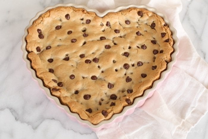 cookie cake with chocolate chips in a heart shaped tart pan