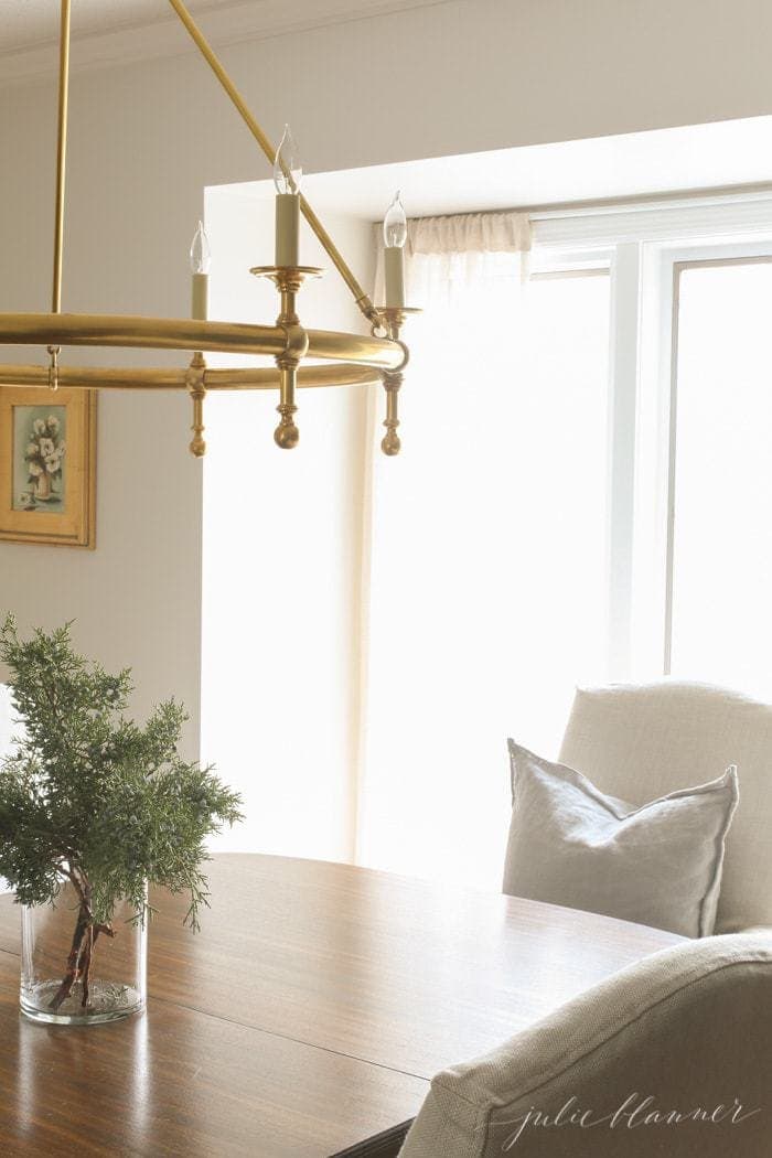 Winter decor in a dining room with fresh greens in a vase.