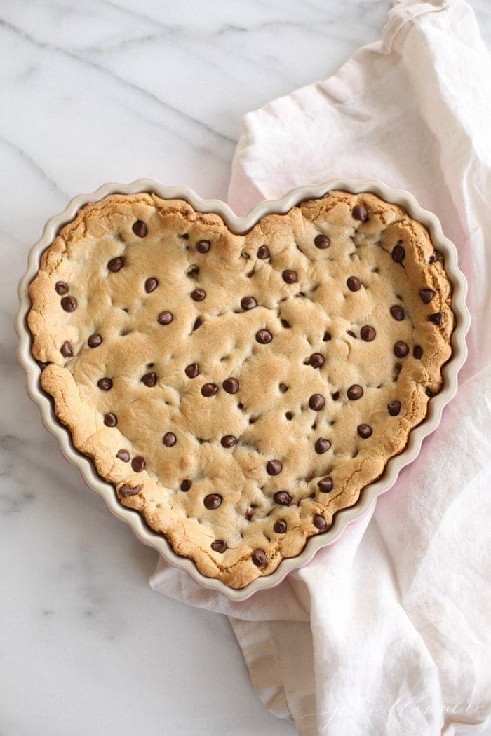 cookie cake with chocolate chips in a heart shaped tart pan