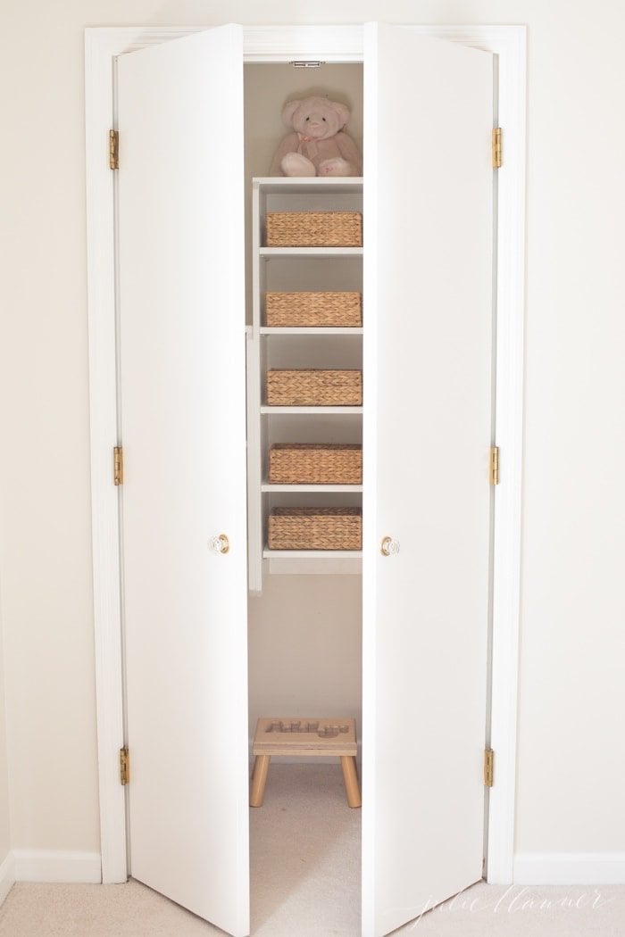 A kid's closet organized with hyacinth baskets for storage