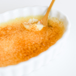Easy creme brulee served in a white dish with a gold spoon.