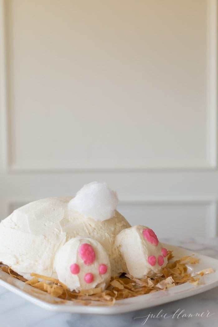 A bunny butt cake on a white platter, tail made of white cotton candy