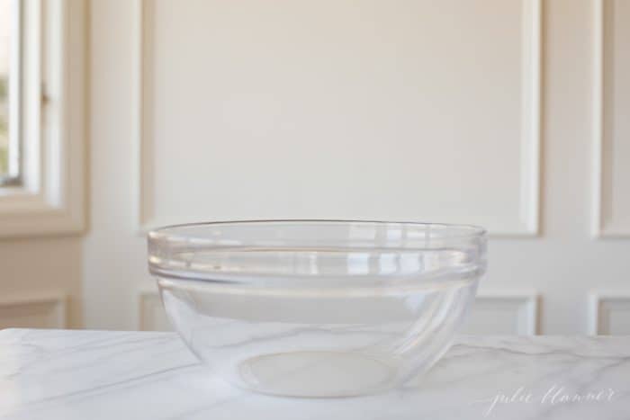 A clear glass pyrex mixing bowl on a marble surface. 