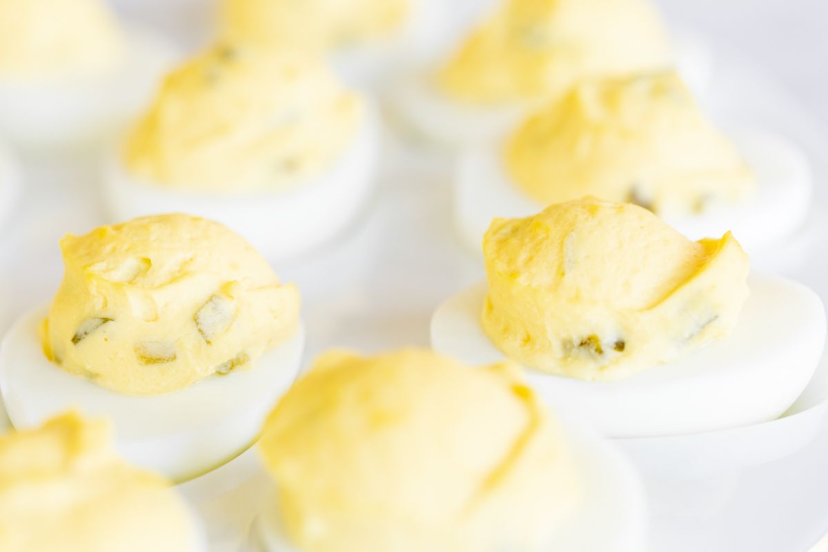 A white deviled egg platter featuring the world's best deviled egg recipe.