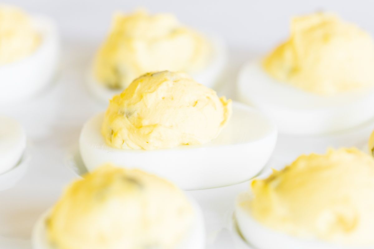 A white deviled egg platter featuring the world's best deviled egg recipe.