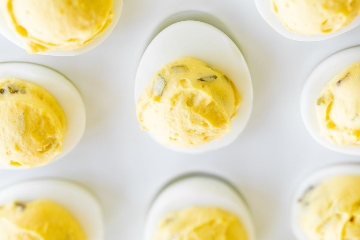 A white deviled egg platter featuring the world's best deviled egg recipe.