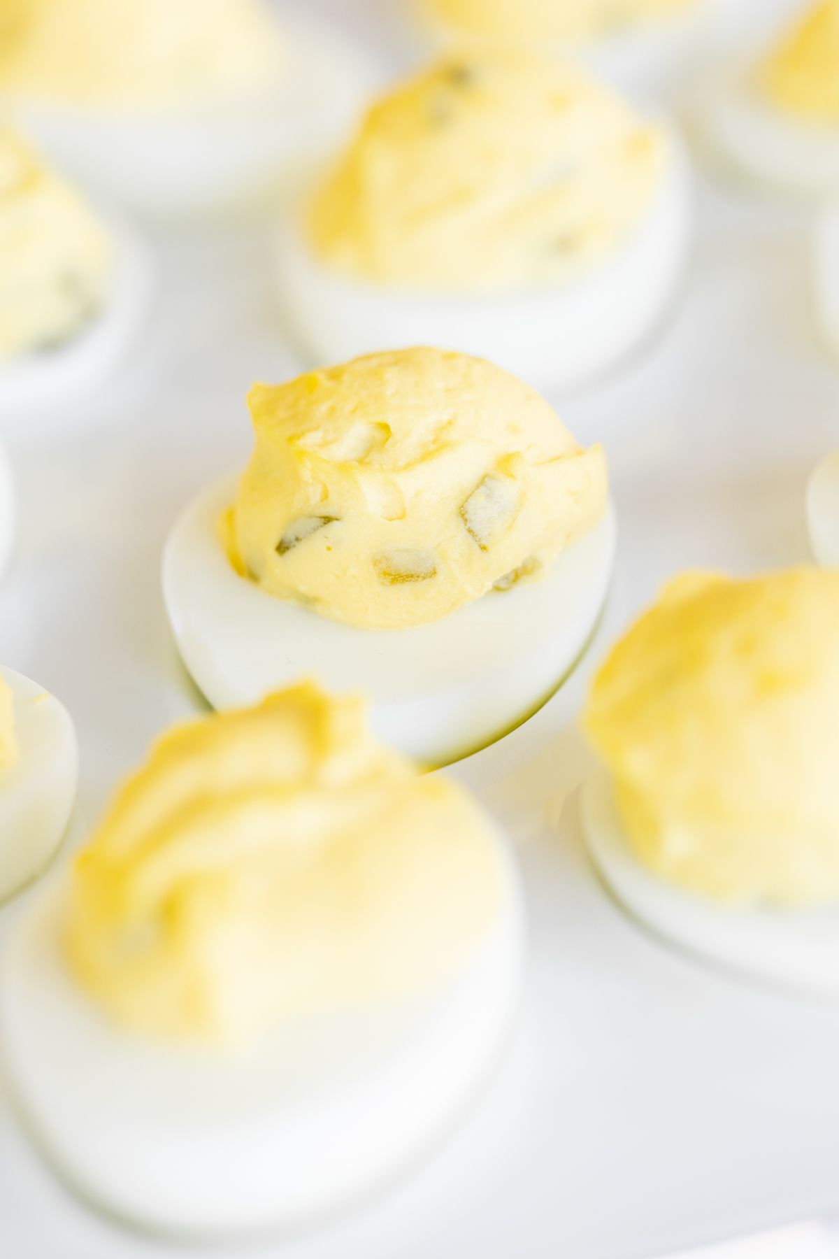 A white deviled egg platter featuring the world's best deviled egg recipe.