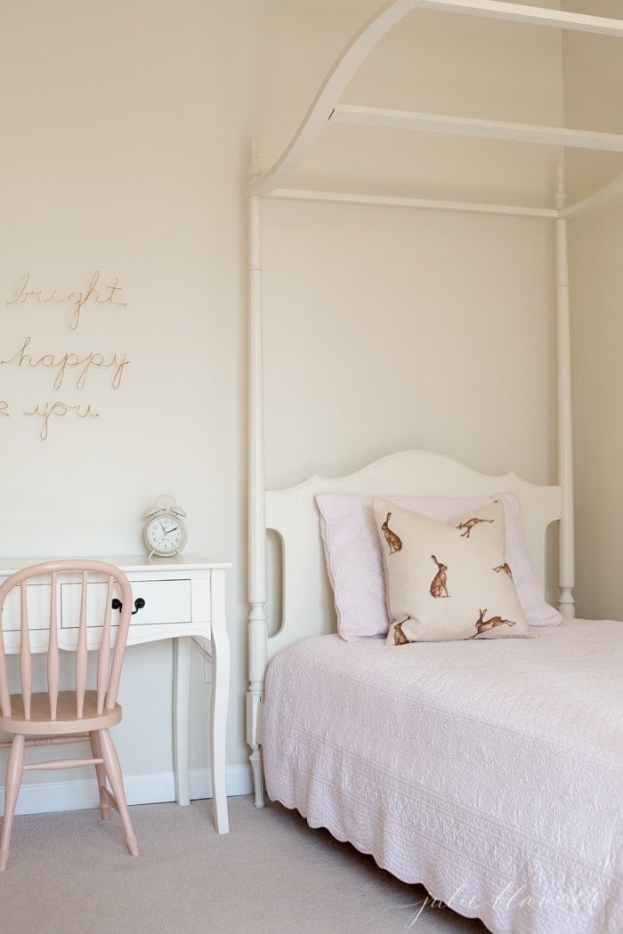 A white girl's bedroom with a bunny pillow for easy Easter decorating.