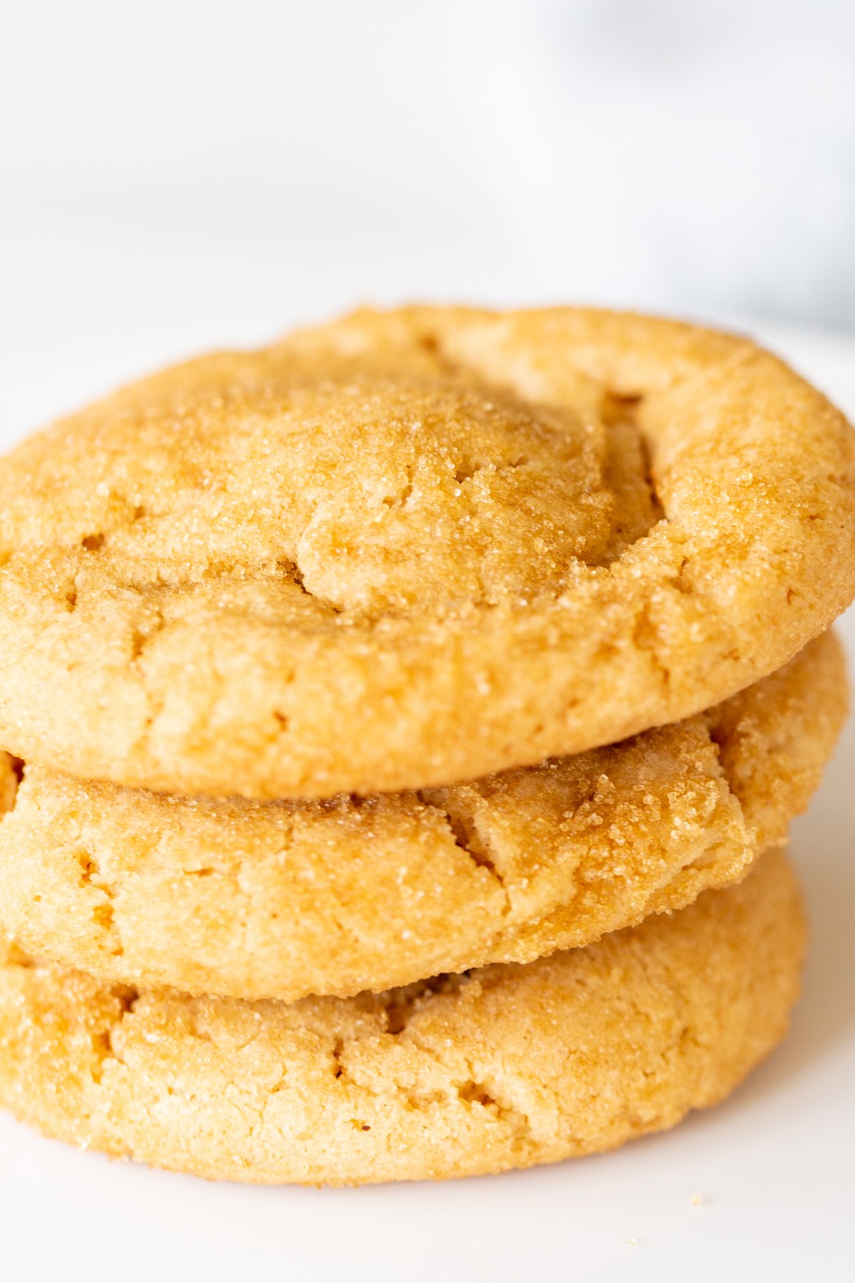 A white plate with a stack of three chocolate stuffed peanut butter cookies.