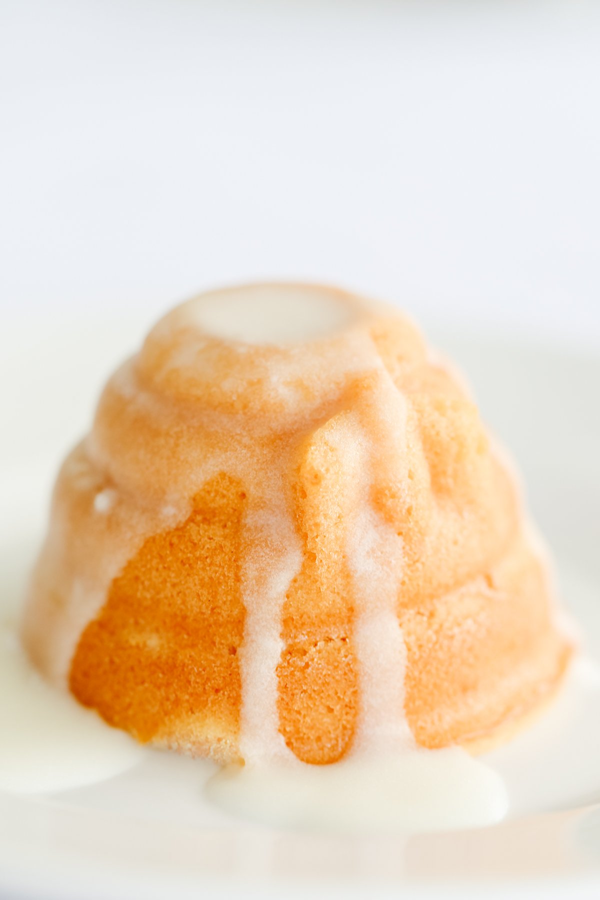 A white plate with a honey lemon cake on it.