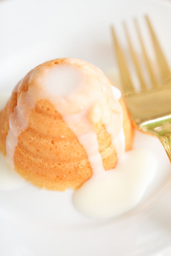 A honey lemon cake on a white plate with a gold fork.