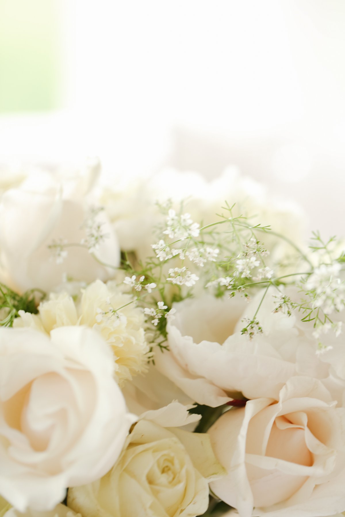 A white peony arrangement in a glass vase.