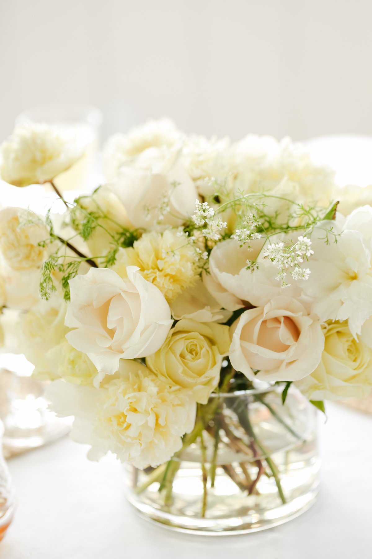 A white peony arrangement in a glass vase.