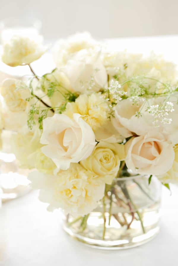 A white peony arrangement in a glass vase.