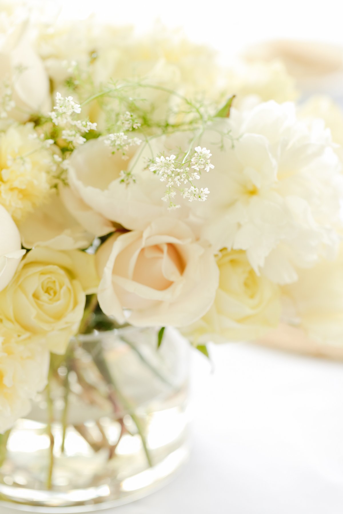 A white peony arrangement in a glass vase.