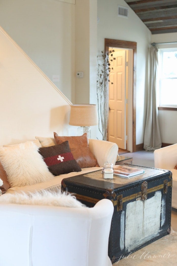 Urban Farmhouse styled living room with white walls, white sofas and rustic coffee table.