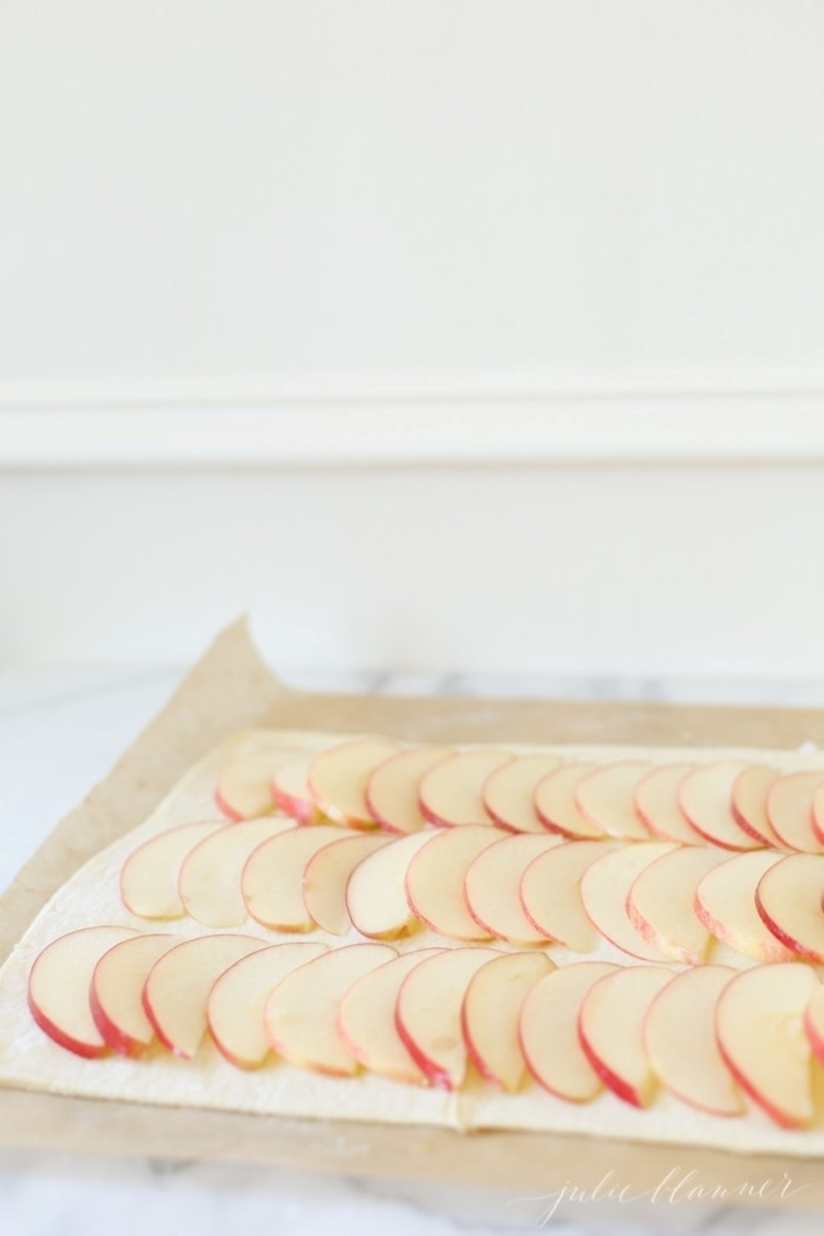 Sliced apples in rows for a caramel apple tart, before it goes into the oven