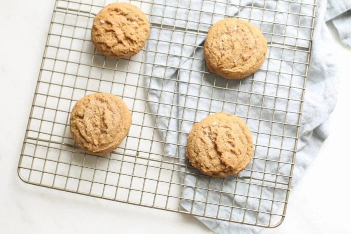 A brown sugar cookie recipe after baking - cookies placed on a wire cooling rack with a blue towel underneath them.