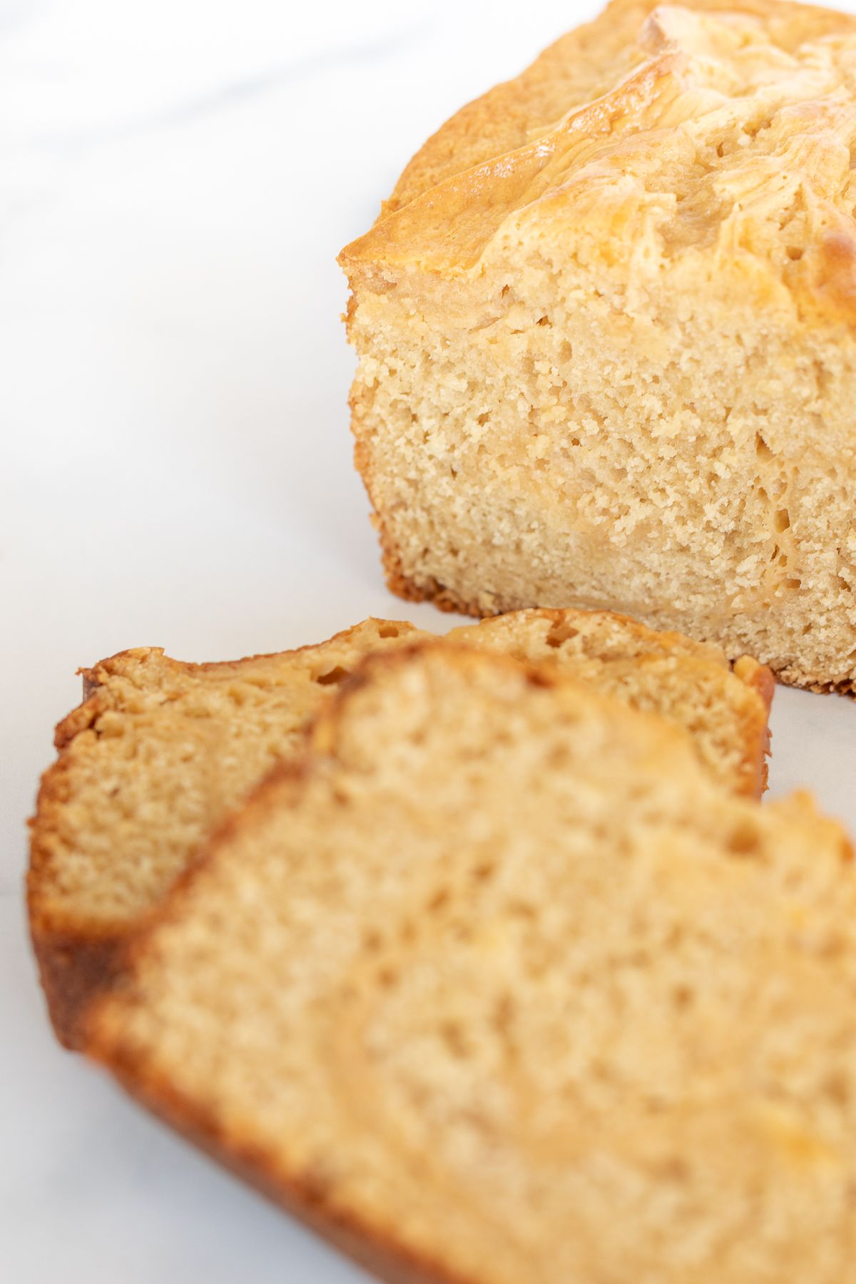 Sliced cream cheese bread with caramel, placed on a marble countertop