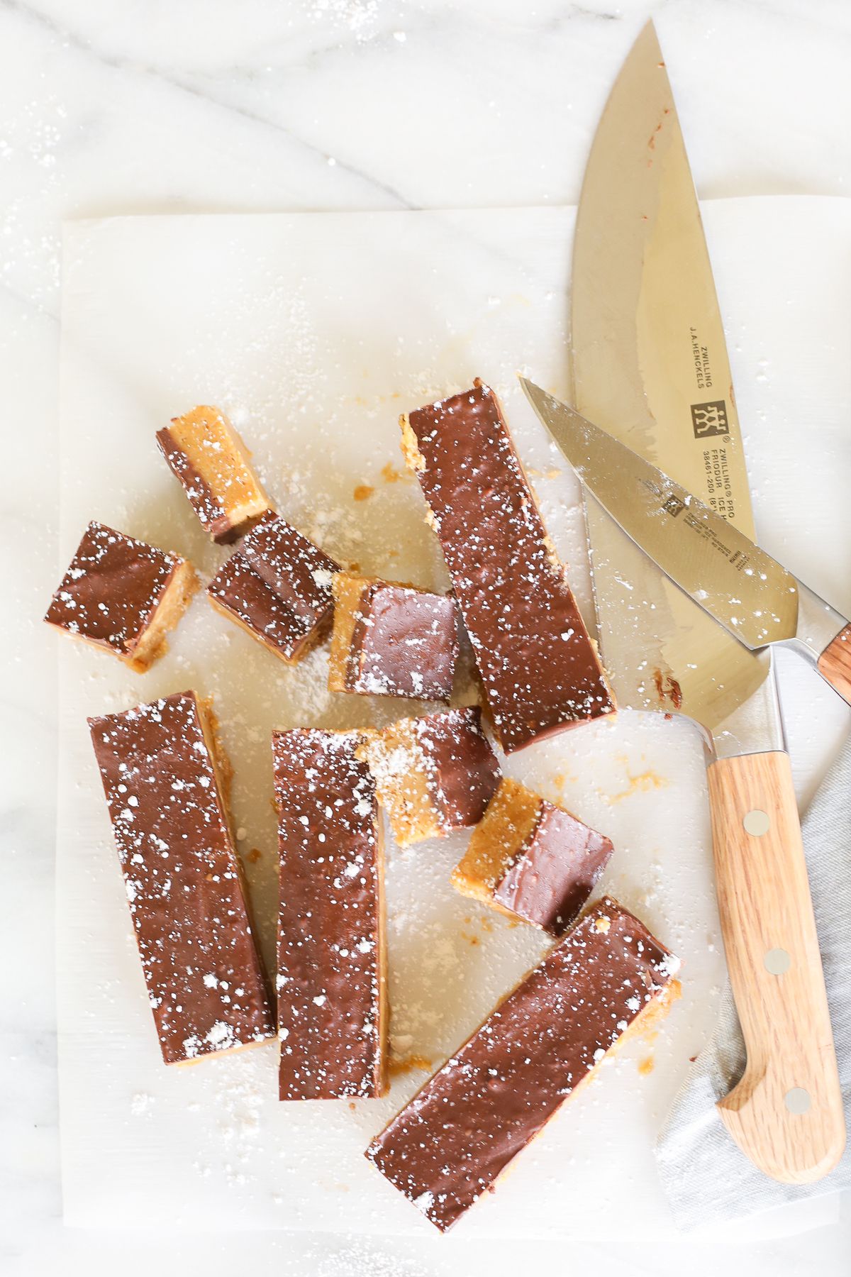 No bake cookie butter bars on a marble countertop, a knife for cutting them nearby. 