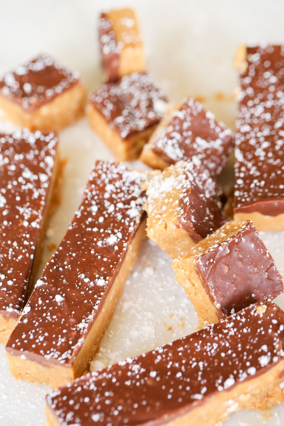 No bake Speculoos cookie butter bars on a marble countertop, dusted with powdered sugar.