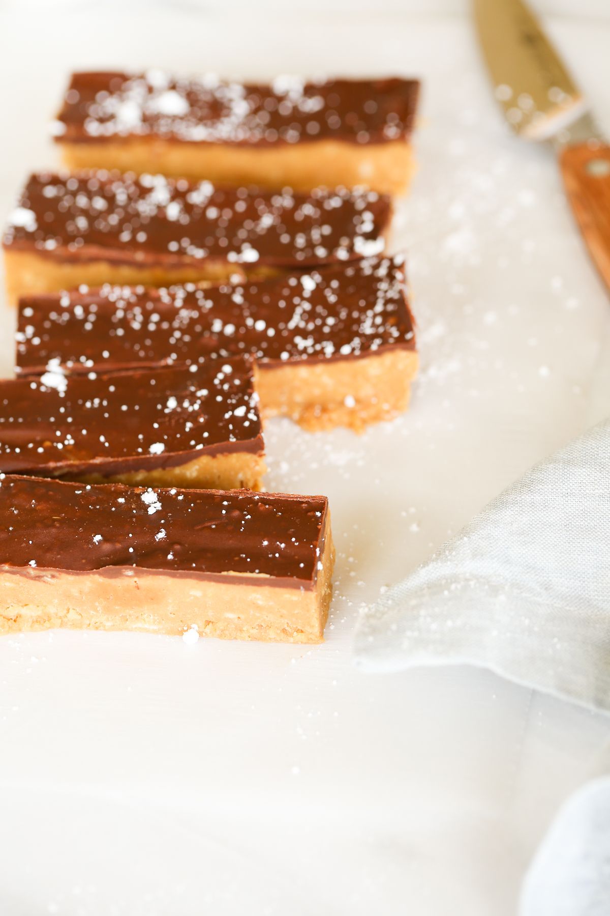 No bake cookie butter bars on a marble countertop, a knife for cutting them nearby.