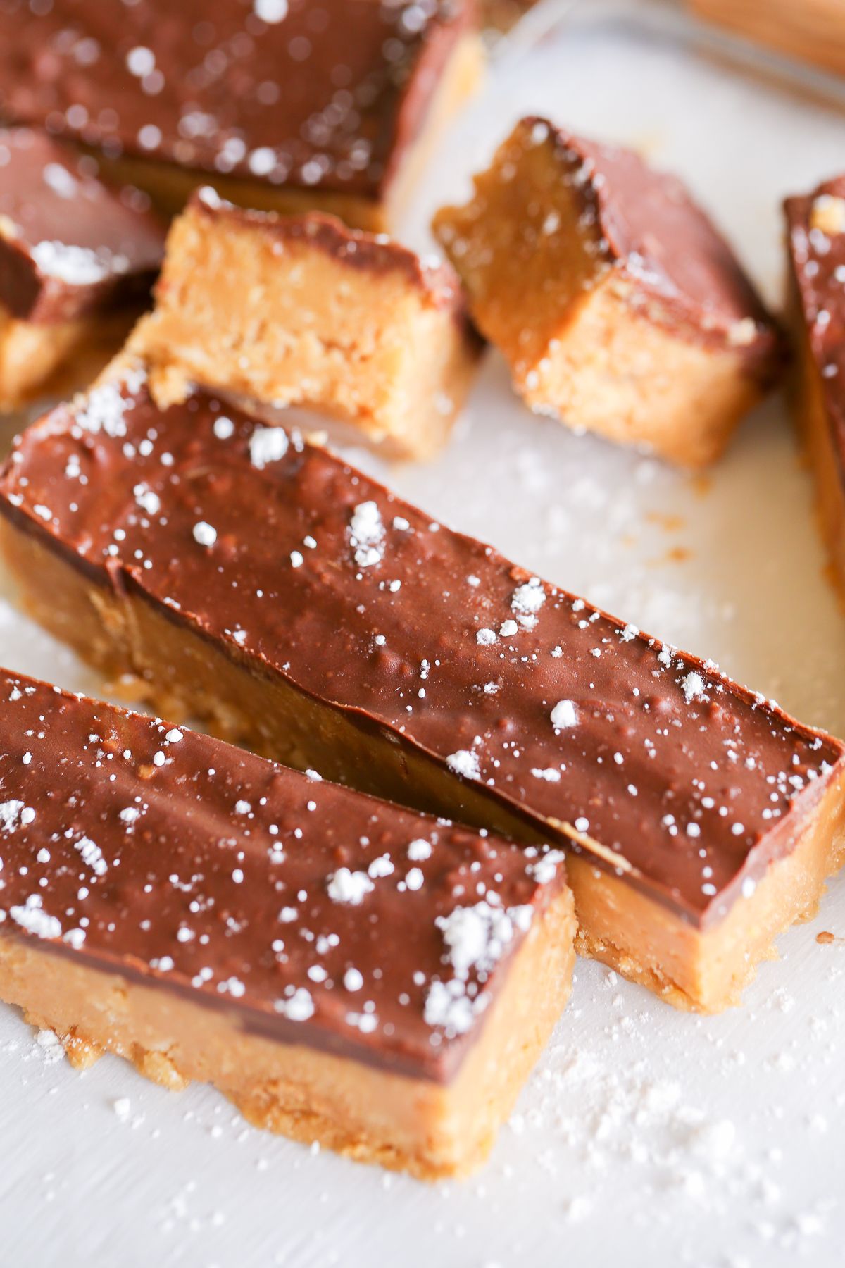 No bake Speculoos cookie butter bars on a marble countertop, dusted with powdered sugar.