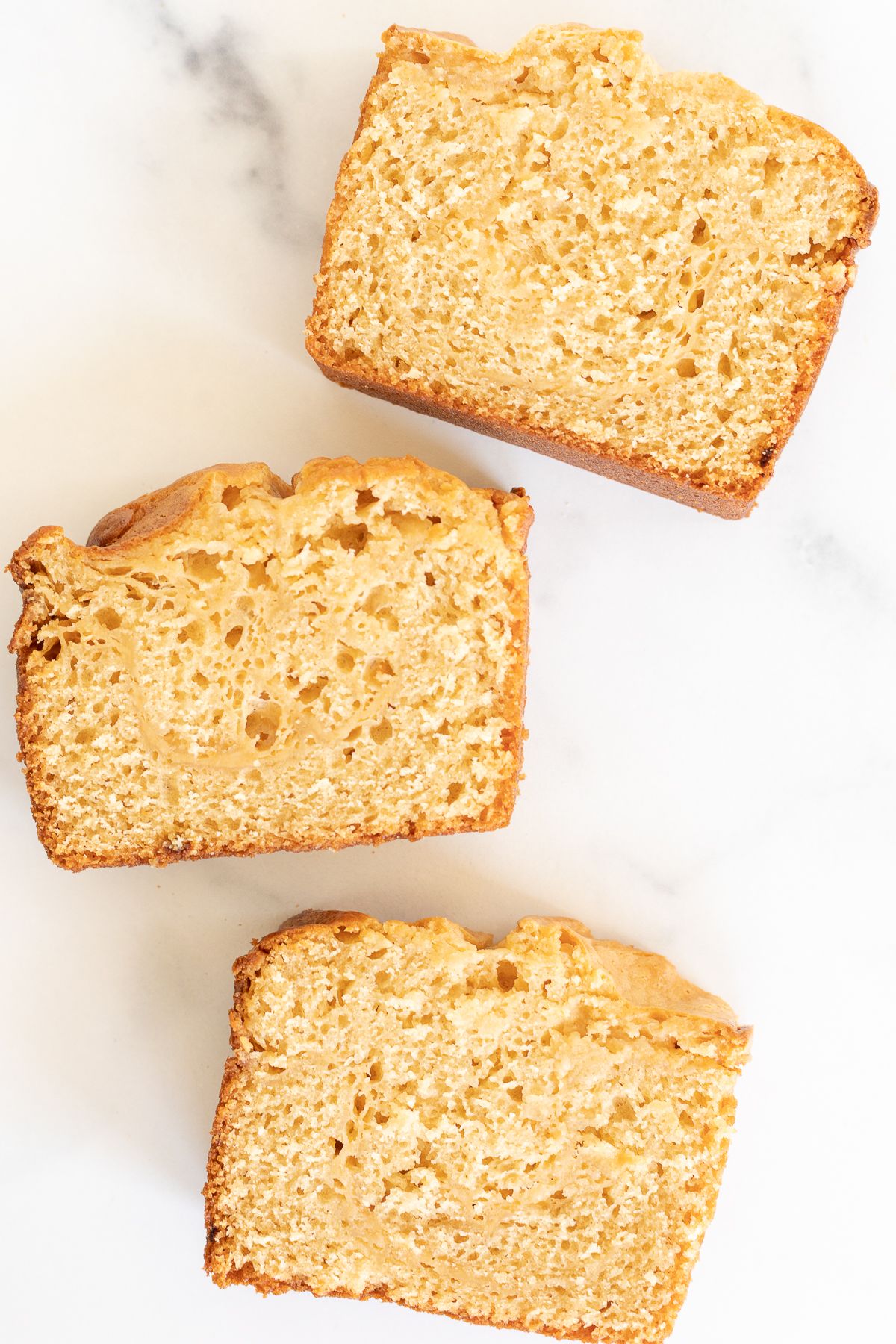 Three slices of cream cheese bread laid out on a marble surface