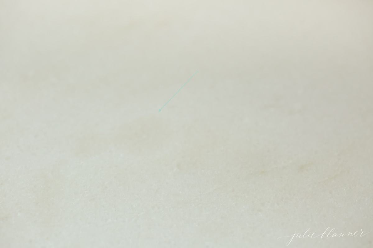 A close up of a marble countertop with an oil stain, after being sealed.