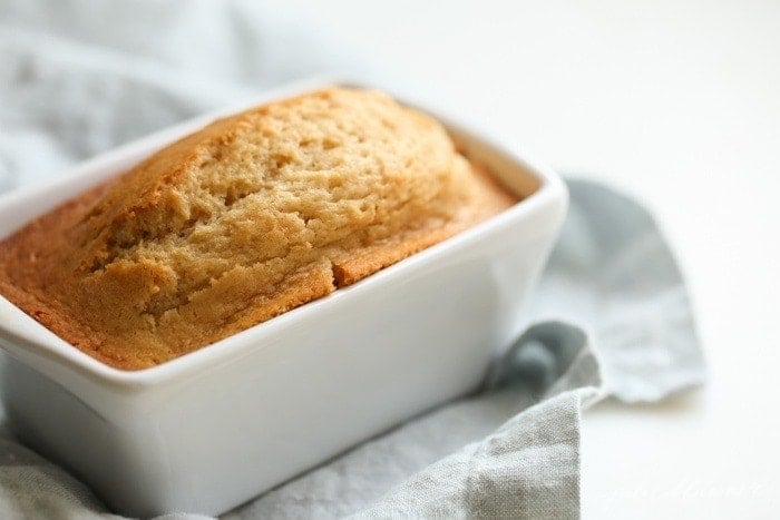 Brown sugar bread in a white ceramic loaf pan. 