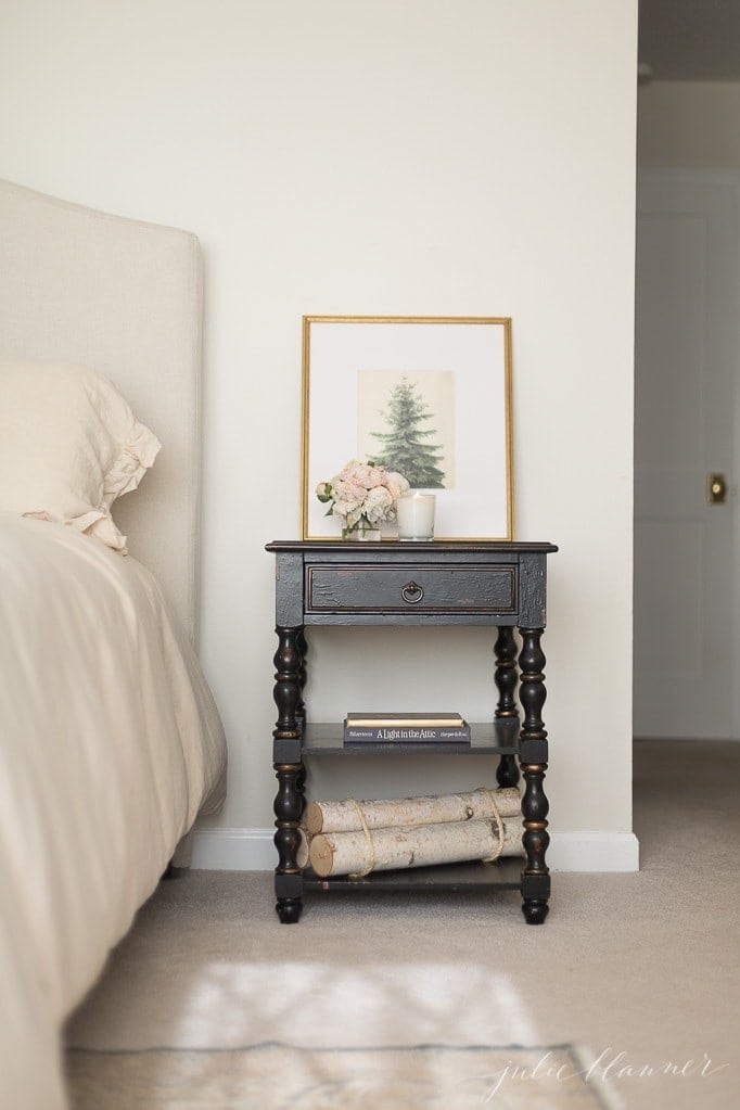 A christmas bedroom with evergreen art and winter decor like birch logs