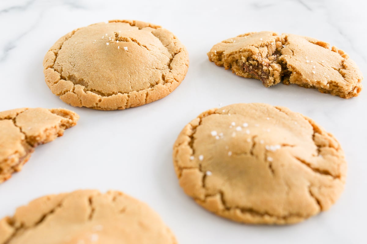 Stuffed peanut butter cookies with a bite taken out of them.