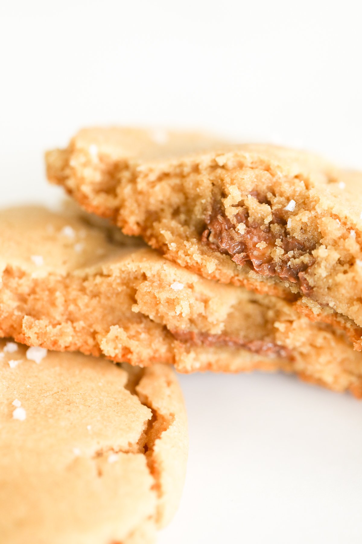 Two stuffed peanut butter cookies with a bite taken out of them.