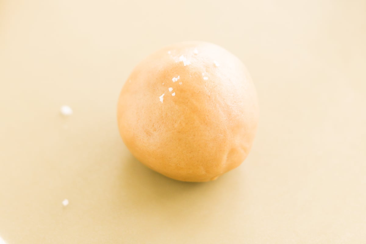 A peanut butter cookie stuffed with an egg on a yellow plate.