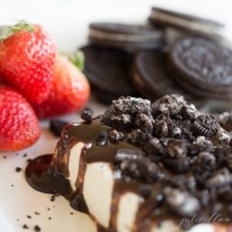 Cookies and cream cheese dip on a plate with strawberries and oreos in background