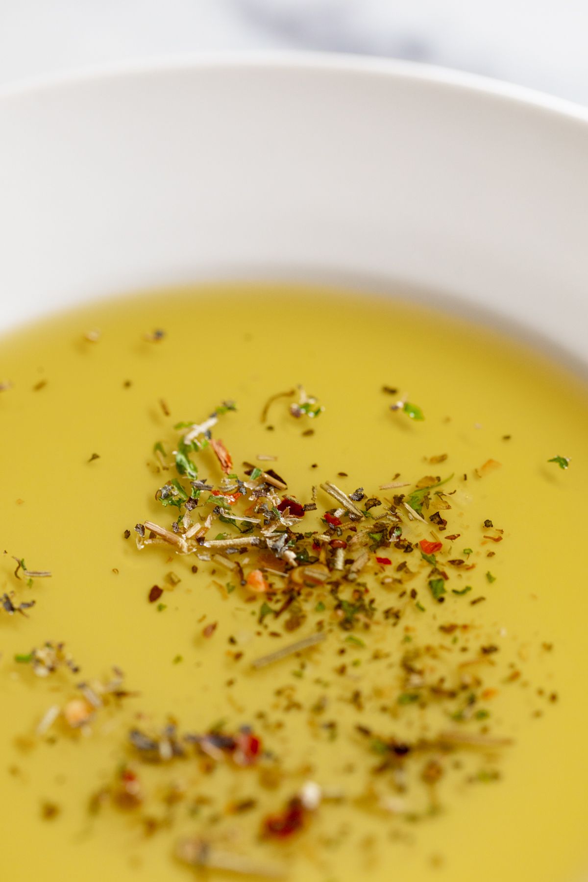 A white plate topped with bread dipping seasoning and olive oil.