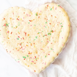 A funfetti cookie cake baked into a heart shaped pan.