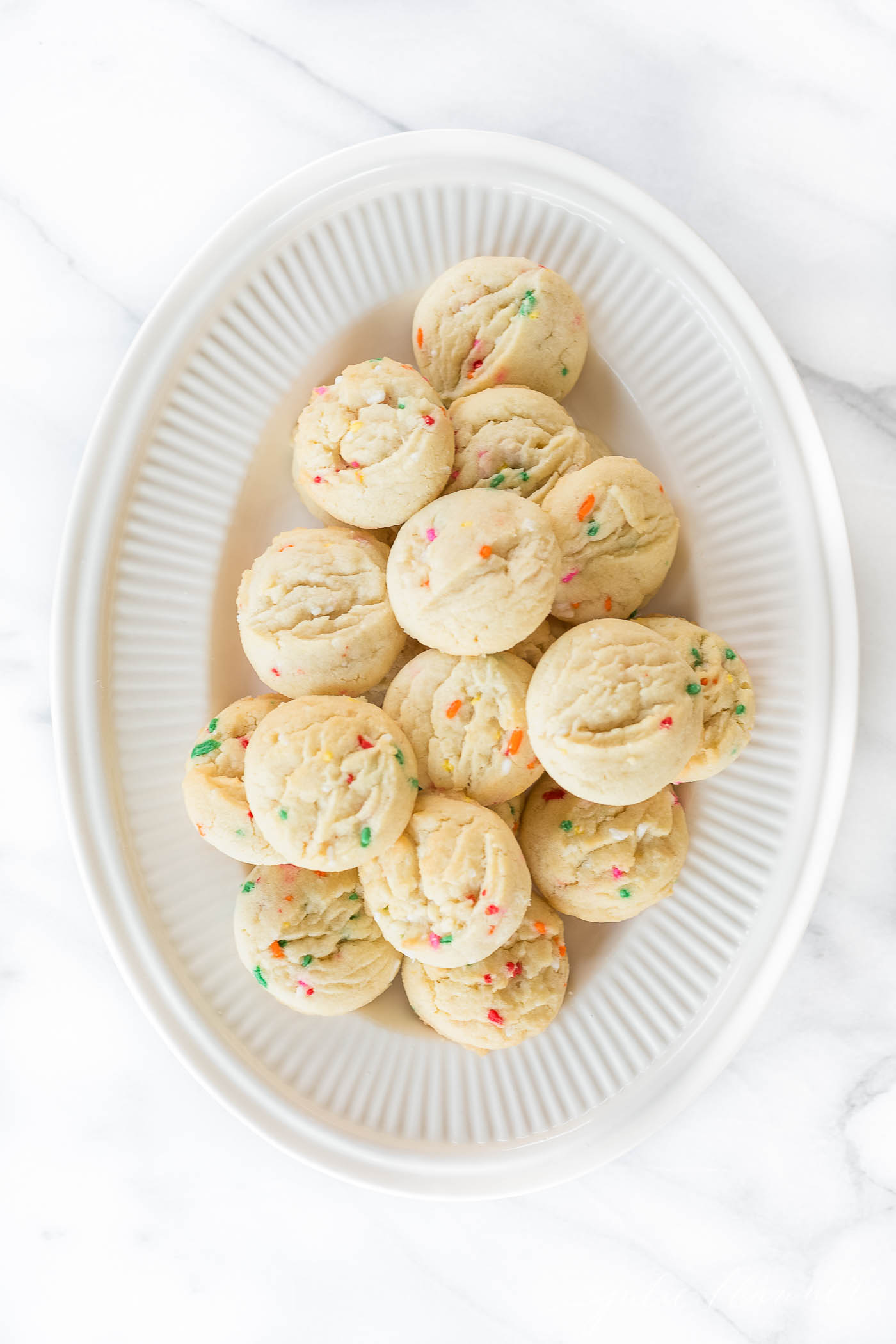 These easy Funfetti Cookies are made in minutes without a cake mix. Perfect for Christmas, Valentine's Day and Birthdays! The best funfetti cookies on a white platter