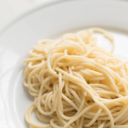 a white plate filled with a swirl of homemade egg noodles