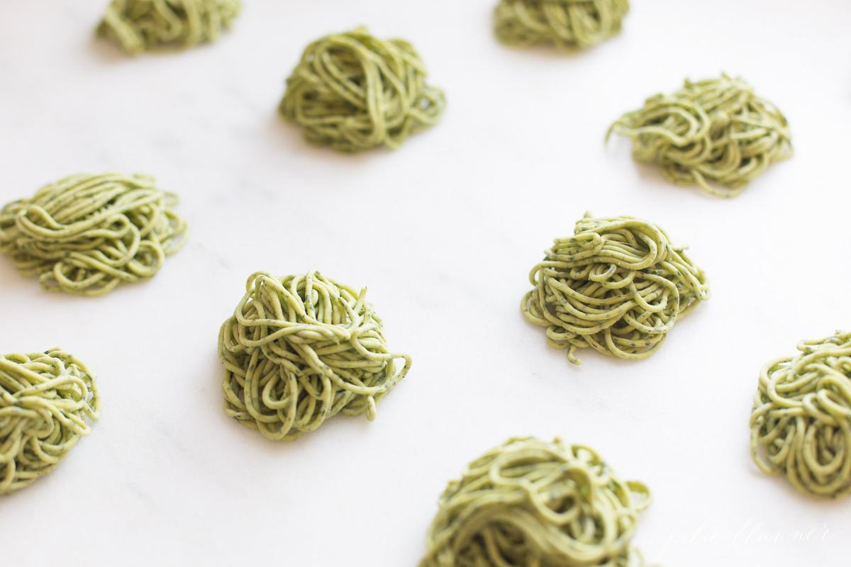 homemade arugula pasta on parchment ready to cook