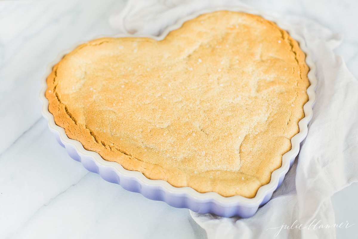 A heart shaped peanut butter cookie cake on a marble countertop.