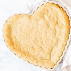 A heart shaped peanut butter cookie cake on a marble countertop.