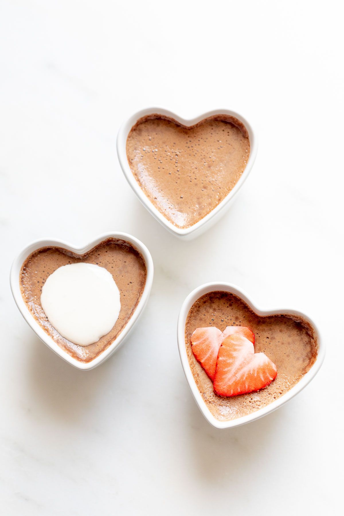 Three small heart shaped ceramic containers of chocolate pots de creme