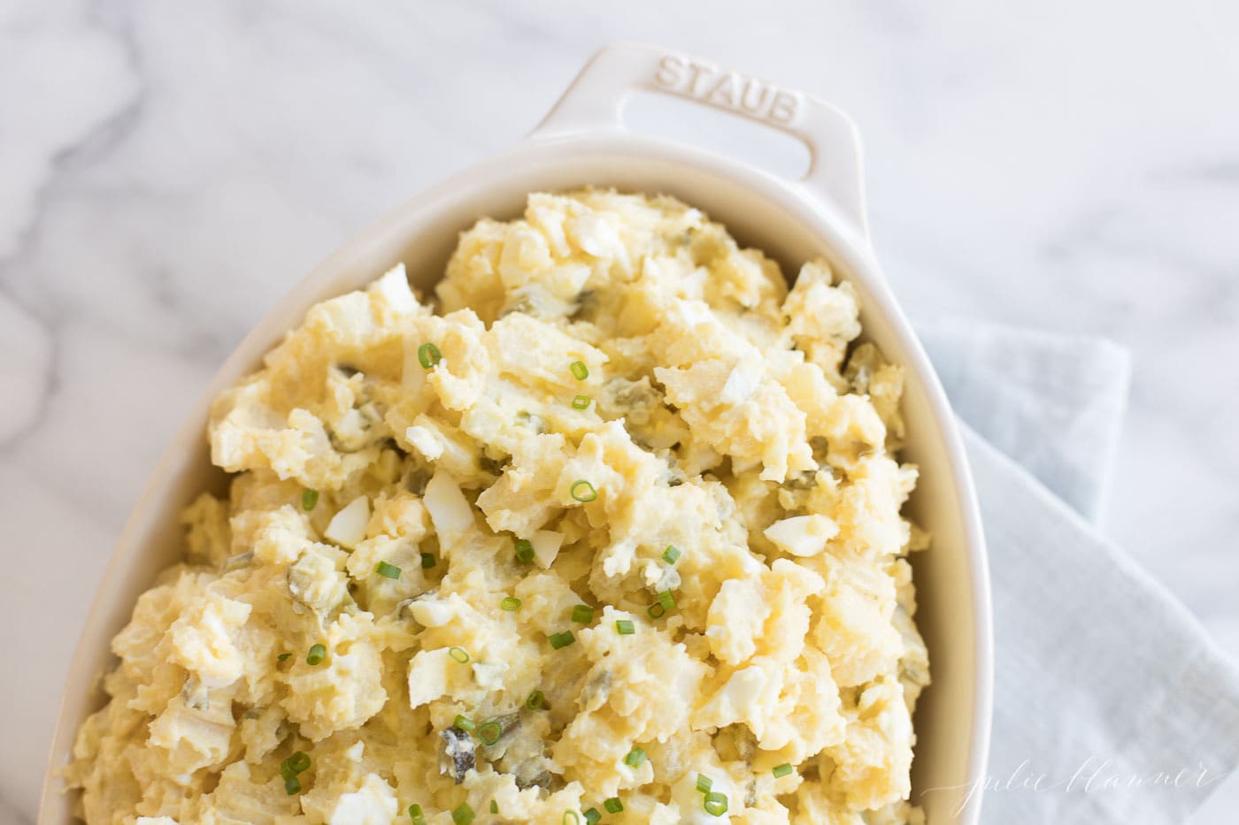 homemade creamy potato salad recipe with eggs in a white casserole dish